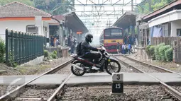 Pengendara motor melintasi palang pintu kereta di pintu pelintasan Kalibata, Jakarta, (4/12). Untuk menekan angka kecelakaan, Pemprov DKI Jakarta berencana membangun flyover diperlintasan kereta api. (Liputan6.com/Yoppy Renato)