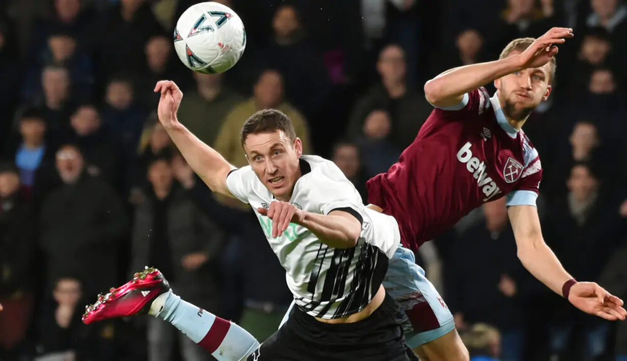 Pemain Derby County Craig Forsyth (kiri) berebut bola dengan pemain West Ham United Tomas Soucek pada pertandingan sepak bola putaran keempat Piala FA di Stadion Pride Park, Derby, Inggris, 30 Januari 2023. West Ham United mengalahkan Derby County dengan skor 2-0. (AP Photo/Rui Vieira)