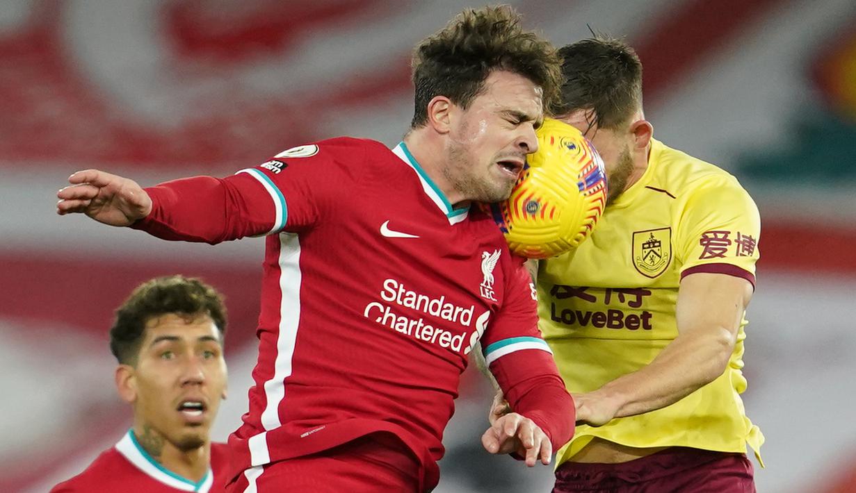 Gelandang Liverpool, Xherdan Shaqiri (kiri) berduel udara dengan gelandang Burnley, Josh Brownhill dalam laga lanjutan Liga Inggris 2020/21 di Anfield Stadium, Liverpool, Kamis (21/1/2021). Liverpool kalah 0-1 dari Burnley. (AFP/Jon Super/Pool)