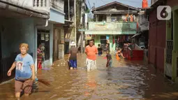Warga beraktivitas di tengah banjir yang merendam kawasan Rawajati, Jakarta Selatan, Sabtu (8/2/2020). Hujan yang terjadi semalaman menyebabkan Sungai Ciliwung kembali meluap hingga membuat rumah warga di kawasan tersebut terendam air setinggi 50 cm hingga 1 m. (Liputan6.com/Immanuel Antonius)
