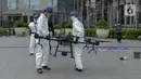 Petugas menyiapkan drone untuk menyemprotkan cairan disinfektan di Jalan Bursa Efek menuju Patung  Pemuda, Jakarta, Jumat (27/3/2020). Penyemprotan dilakukan untuk mencegah penyebaran virus corona COVID-19. (merdeka.com/Imam Buhori)
