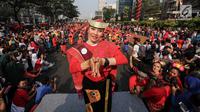 Seorang penari diikuti ribuan peserta membawakan Tari Tortor dari Sumatera Utara saat CFD di Senayan, Jakarta, Minggu (12/8). Kegiatan ini digelar menyambut HUT Ke-73 RI dan Asian Games 2018. (Liputan6.com/Fery Pradolo)