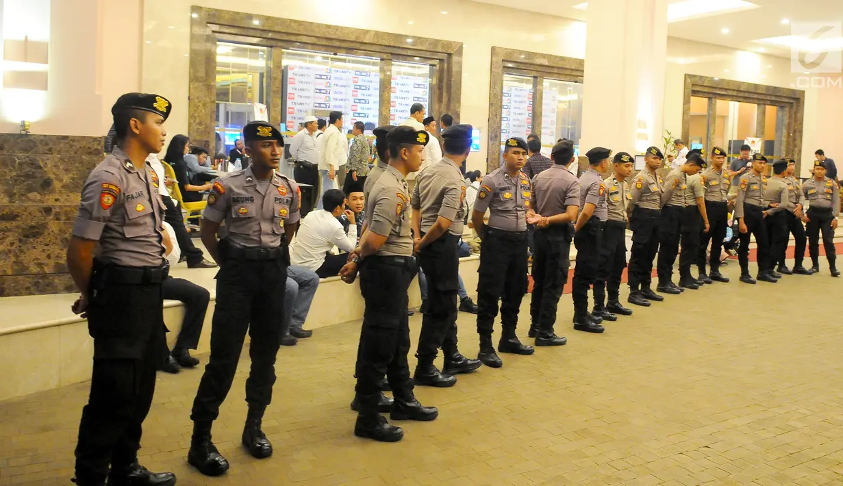 Aparat Kepolisian berjaga di depan pintu masuk lobby debat cawapres 2019 di Hotel Sultan, Jakarta, Minggu (17/3). Polisi menerapkan empat ring pengamanan yang dijaga oleh Paspampres, TNI Polri, dan Polda Metro Jaya. (Liputan6.com/Angga Yuniar)