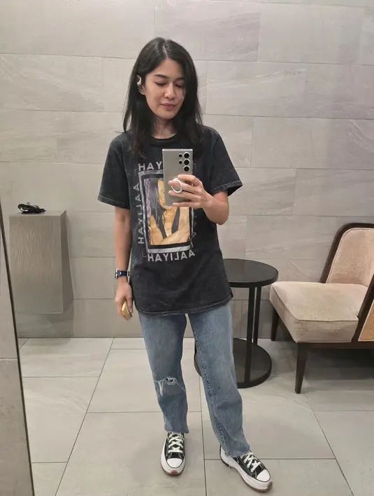Dian Sastrowardoyo tampil boyish ala anak band dengan baju longgar. Ia kenakan t-shirt grafis hitam dengan ripped jeans dans neakers Converse hitam putih. [@therealdisastr]