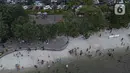 Pemandangan udara warga berlibur di Pantai Ancol, Pademangan, Jakarta Utara, Rabu (1/6/2022). Libur Nasional Hari Lahir Pancasila, dimanfaatkan warga mengajak sanak saudara tamasya di Pantai Ancol. (Liputan6.com/Herman Zakharia)