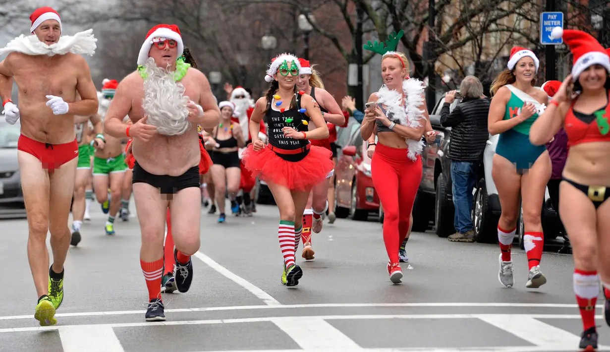 Pelari berjalan menyusuri Newbury Street selama Santa Speedo Run di Boston, Massachusetts, Sabtu (14/12/2019). Speedo Run adalah perlombaan lari menjelang Natal dengan peserta pria hanya menggenakan celana dalam dan wanita memakai bikini beserta topi ala Sinterklas. (Joseph Prezioso/AFP)