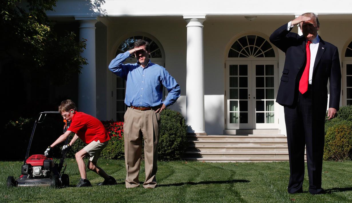 Presiden AS, Donald Trump melihat hasil kerja Frank Giaccio saat memotong rumput di Rose Garden, Gedung Putih, Jumat (15/9). Dalam suratnya, bocah 11 tahun itu menulis bahwa ini adalah kehormatan baginya memotong rumput Gedung Putih. (AP/Jacquelyn Martin)