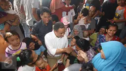 Warga bersalaman dengan Calon gubernur DKI Jakarta Anies Baswedan saat blusukan di Kampung Maja, Pegadungan, Jakarta Barat, Senin (7/11). (Liputan6.com/Immanuel Antonius)