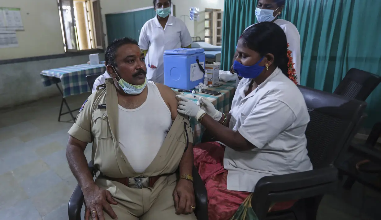 Petugas kesehatan memberikan dosis ketiga vaksin COVID-19 kepada polisi di pusat rumah sakit polisi pemerintah di Hyderabad, India (10/1/2022). India melaporkan 179.723 kasus baru pada Senin (10/1), sebagian besar berada di kota-kota terbesar Delhi, Mumbai dan Kalkuta. (AP Photo/Mahesh Kumar A.)