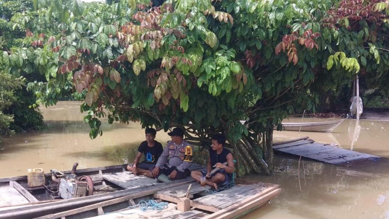 Cara Unik Personel Polri Sampaikan Pesan Pilkada Damai dari Atas Perahu