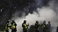 Tetapi pihak keamanan melakukan kebijakan yang kontroversial. Mereka justru menggunakan gas air mata untuk membubarkan massa yang terus merengsek ke dalam lapangan. Langkah tersebut justru membuat kondisi di lapangan makin runyam. (AP/Yudha Prabowo)