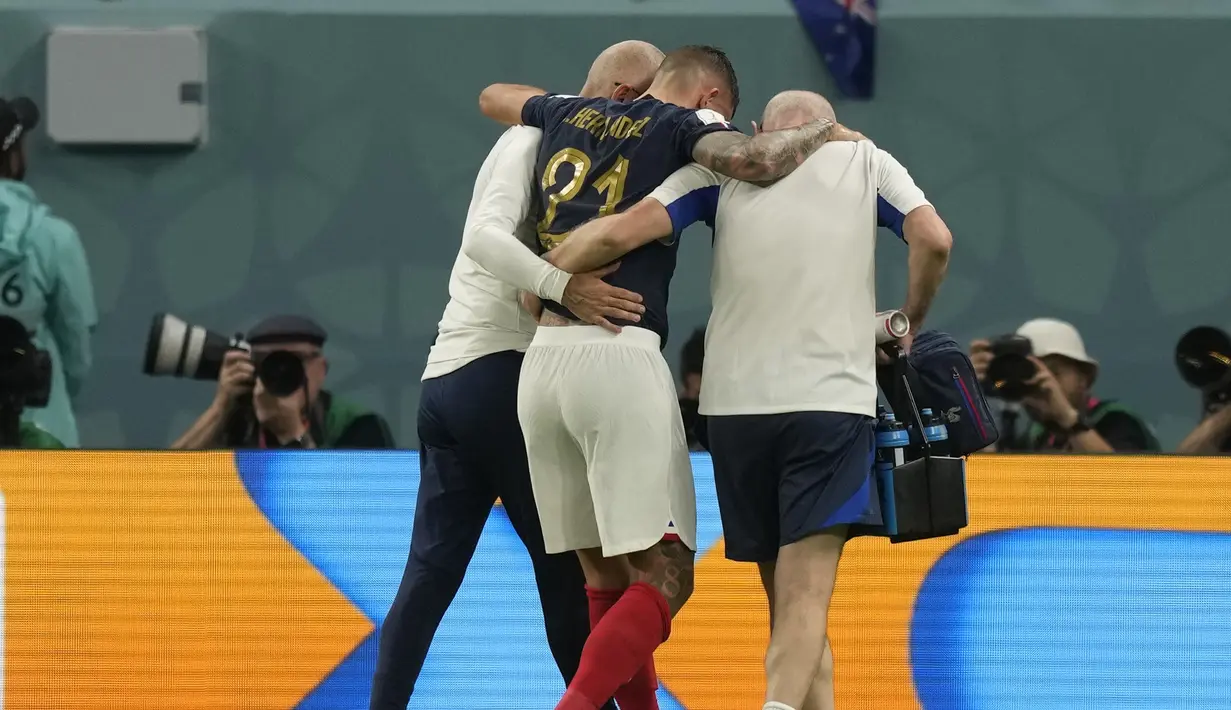 Bek timnas Prancis, Lucas Hernandez dibantu keluar lapangan pada penyisihan  Grup D Piala Dunia 2022 kontra Australia di Al Janoub Stadium, Rabu (23/11/2022) dini hari WIB. Akibat cedera itu, Lucas Hernandez dipastikan tidak akan tampil lagi di sisa laga Prancis di Piala Dunia 2022 Qatar. (AP Photo/Frank Augstein)