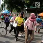 Seniman berkostum boneka Doraemon menggoda warga saat kegiatan Car Free Day di Bundaran HI di Jakarta, Minggu, (12/11). Kegiatan tersebut bermaksud untuk menghibur warga. (Liputan6.com/Fery Pradolo)