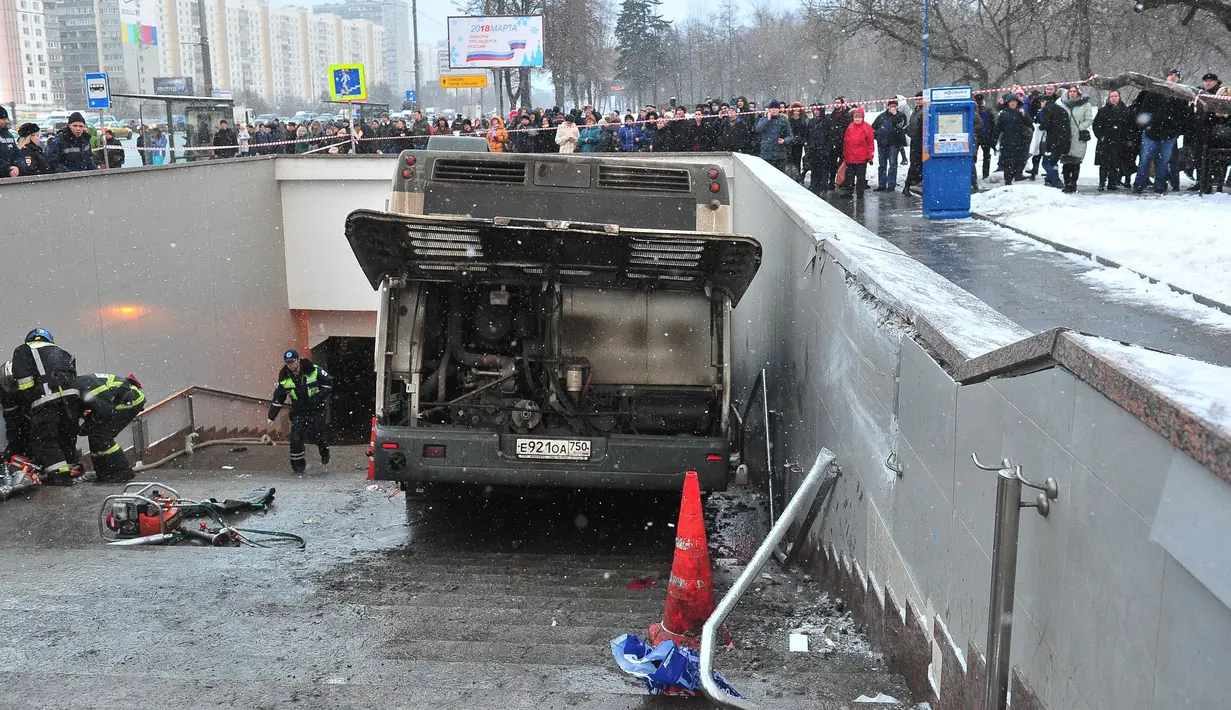 Petugas penyelamat di lokasi bus yang hilang kendali dan masuk ke dalam tangga menuju jalan bawah tanah di Moskow, Rusia, Senin (25/12). Insiden terjadi di jam sibuk pagi hari saat sedang ramai dengan pejalan kaki yang beraktivitas. (AP/Ivan Sekretarev)