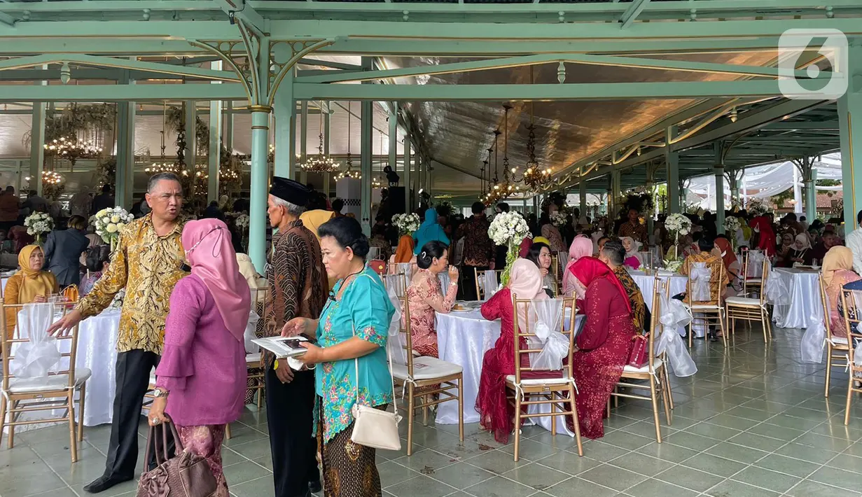 Sejumlah warga mengantre untuk bersalaman dengan putra bungsu Presiden Joko Widodo, Kaesang Pangarep dan istrinya Erina Gudono pada acara Ngunduh Mantu pernikahan di Pura Mangkunegaran, Solo, Minggu (11/12/2022). Antrean tamu undangan yang ingin berfoto dengan Kaesang Pangarep dan Erina Gudono beserta keluarga mengular panjang bahkan rela berdesak-desakan demi bisa berfoto dengan kedua mempelai. (Liputan6.com/Herman Zakharia)