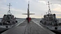 Para prajurit Angkatan Laut Perancis berbaris di atas kapal selam nukir Triumphant "Le Vigilant" yang dikawal oleh dua kapal tunda sebelum menjalankan misi penyelaman, Brest, Prancis (21/10). (AFP /Valérie Leroux )