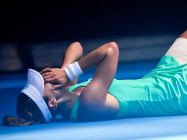 Petenis Prancis, Alize Cornet tergeletak di lapangan akibat cuaca yang begitu panas saat bertanding melawan petenis Belgia Elise Mertens di kejuaraan tenis Australia Terbuka di Melbourne, Australia, (19/1). (AP Photo / Andy Brownbill)