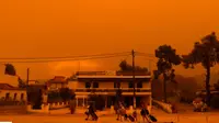 Warga setempat meninggalkan rumah mereka di Pulau Evia, Yunani di tengah kebakaran hutan hebat hari Minggu (8/8). (AP)
