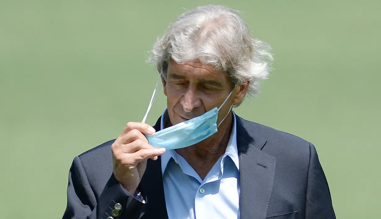 Pelatih Real Betis asal Chile, Manuel Pellegrini melepas masker saat berpose selama presentasinya sebagai pelatih baru di stadion Benito Villamarin di Seville (13/7/2020). Eks pelatih Real Madrid ini dikontrak Real Betis mulai musim depan dengan ikatan kontrak sampai 2023. (AFP/Cristina Quicler)