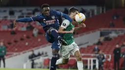 Striker Arsenal, Folarin Balogun (kiri), melepaskan tendangan dibawah tekanan bek Rapid Wien, Leo Greiml, dalam laga lanjutan Liga Europa 2020/21 Grup B di Emirates Stadium, Kamis (3/12/2020) waktu setempat. Arsenal mengalahkan Rapid Wien 4-1. (AFP/Adrian Dennis)