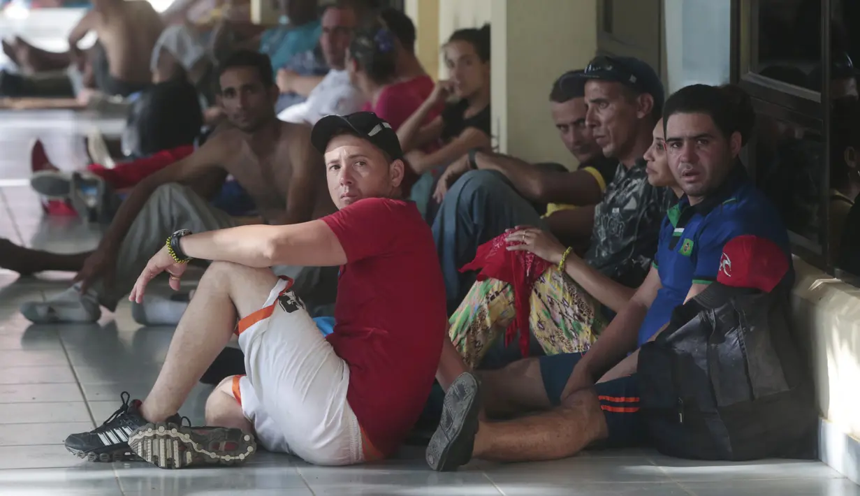 Sejumlah imigran Kuba beristirahat di luar gedung bea cukai di perbatasan antara Nikaragua dan Kosta Rika, Minggu (15/11). Nikaragua menutup perbatasannya dengan Kosta Rika hingga ribuan orang yang menuju Amerika terlantar. (REUTERS/Oswaldo Rivas)
