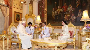 Paus Fransiskus berbincang dengan Raja Thailand Maha Vajiralongkorn (tengah) dan Ratu Suthida (kanan) di Istana Dusit, Bangkok (22/11/2019). Pertemuan dilakukan setelah Paus Fransiskus merayakan misa dengan puluhan ribu umat Katolik Thailand. (Handout/Thai Royal Household Bureau/AFP)