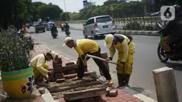 Petugas Bina Marga memerlebar saluran air di Jalan TB Simatupang di kawasan Cilandak, Jakarta, Kamis (22/10/2020). Hal tersebut dilakukan guna memaksimalkan fungsi sistem drainase agar tidak terjadi genangan air saat menghadapi musim hujan. (Liputan6.com/Immanuel Antonius)