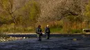 Seorang nelayan melemparkan pancingnya saat dia memancing ikan trout di Credit River di antara warna-warni musim gugur di Mississauga, Ontario, pada Kamis, 27 Oktober 2022. (Nathan Denette/The Canadian Press via AP)