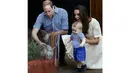 Pangeran George sedikit tersenyum melihat ayahnya, Pangeran William mengusap binatang yang yang kelahirannya berbarengan dengan sang pewaris tahta kerajaan Inggris itu. (20/4/2014). (REUTERS/Chris Jackson)
