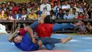 Wanita Kamboja bersaing dalam pertandingan gulat Khmer selama festival Pchum Ben, festival kematian, di desa Vihear Suor di provinsi Kandal (9/10). (AFP Photo/Tang Chhin Sothy)