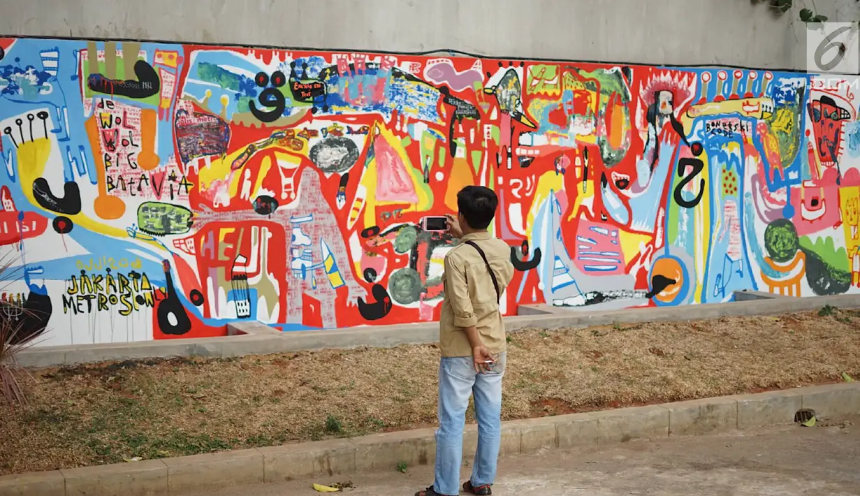 Warga melihat mural yang menghiasi tembok dalam acara Mural Cikini Project #1 di Taman Plaza Teater Besar, Taman Ismail Marzuki, Jakarta, Jumat (23/8/2019). Project #1/Mural Cikini yang diikuti oleh 4 seniman digelar dalam rangka menata estetika ruang publik. (Liputan6.com/Faizal Fanani)