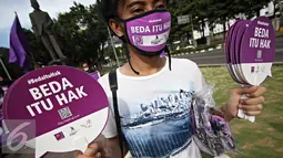 Massa Aliansi Jurnalis Independen melakukan aksi damai dengan membagikan masker dan kipas kepada pengendara di Jakarta, Selasa (3/5). AJI juga menyatakan bahwa musuh kebebasan pers 2016 adalah kepolisian. (Liputan6.com/Immanuel Antonius)