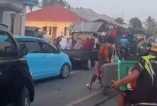 Warga berlarian menjauhi pantai saat air laut surut usai gempa. (Liputan6.com/Ola Keda)