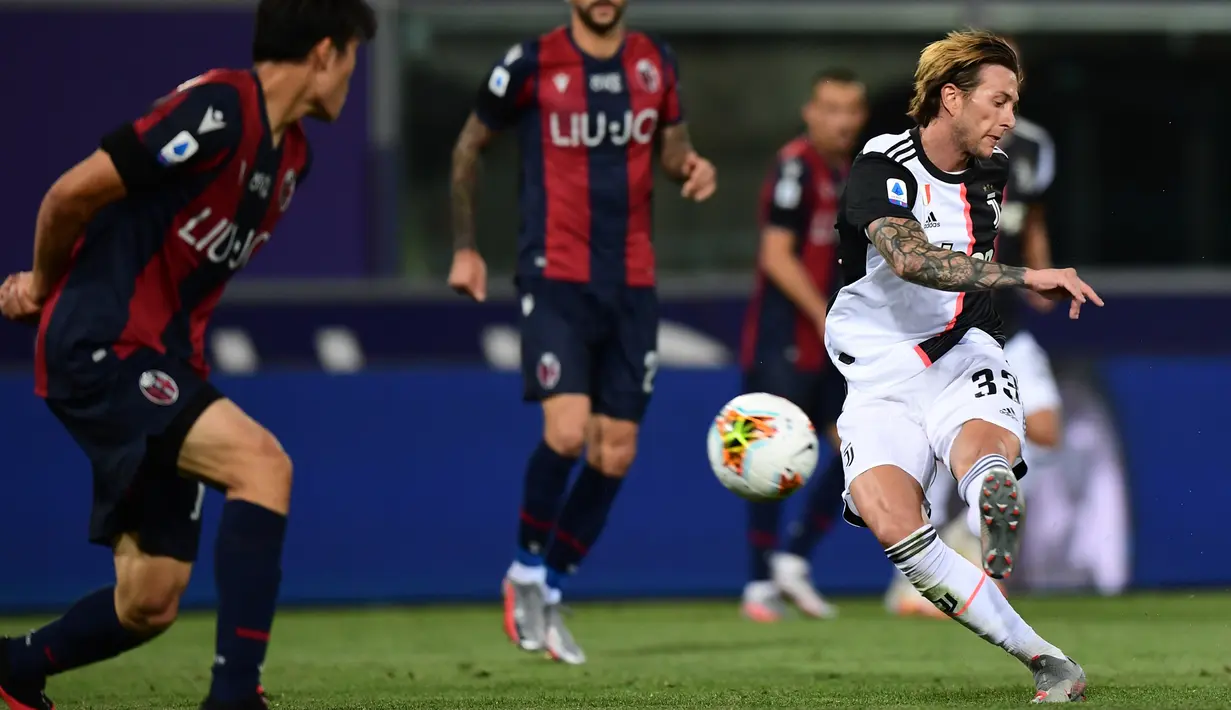 Gelandang Juventus, Federico Bernardeschi (kanan) berusaha menembak bola ke arah gawang Bologna pada pertandingan lanjutan liga Serie A Italia di stadion Renato-Dall'Ara di Bologna (22/6/2020). Juventus menang 2-0 atas Bologna. (Miguel MEDINA / AFP)