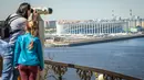 Wisatawan melihat keindahan Nizhny Novgorod Arena dengan terpong di Nizhny Novgorod (21/5/2018). Stadion Novgorod akan menjadi tuan rumah untuk empat pertandingan grup, babak 16 besar dan perempat final. (AFP/Mladen Antonov)