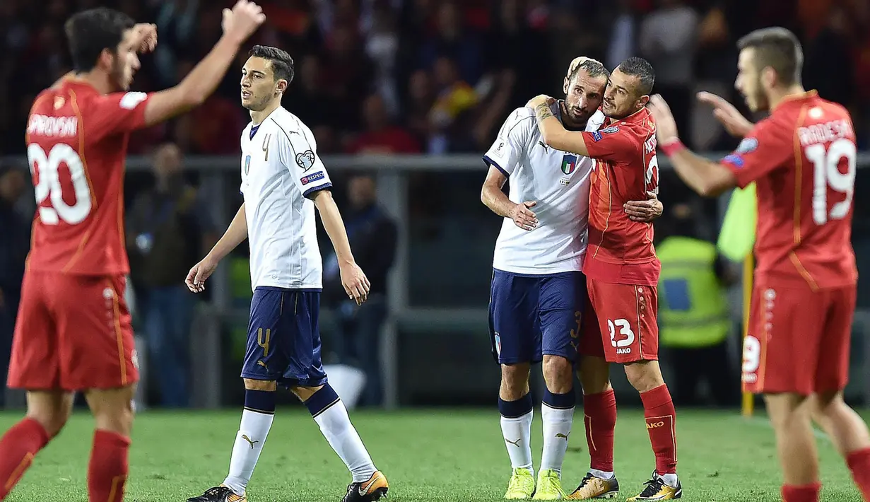 Striker Makedonia, Ilija Nestorovski, memeluk bek Italia, Giorgio Chiellini, pada laga Kualifikasi Piala Dunia 2018 di Stadion Olimpico, Turin, Jumat (6/10/2017). Italia ditahan imbang 1-1 dengan Makedonia. (AP/Alessandro Di Marco)