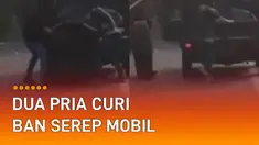 Sebuah rekaman video menunjukkan detik-detik dua pria mencuri ban serep mobil.