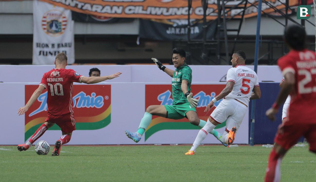 <p>Kiper Persis Solo, Muhammad Riyandi (tengah) berusaha memotong bola yang dilepaskan pemain Persija Jakarta, Hanno Behrens dalam laga pekan ke-2 BRI Liga 1 2022/2023 antara Persija Jakarta melawan Persis Solo di Stadion Patriot Candrabhaga, Bekasi, Minggu (31/7/2022) sore WIB. (Bola.com/Ikhwan Yanuar)</p>