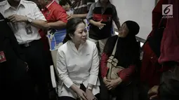 Menko PMK, Puan Maharani berbincang dengan salah satu pemudik di dalam kereta sebelum keberangkatan di Stasiun Senen, Jakarta, Rabu (21/6). Puan juga menggunakan topi kepala stasiun untuk menandai keberangkatan kereta. (Liputan6.com/Faizal Fanani)