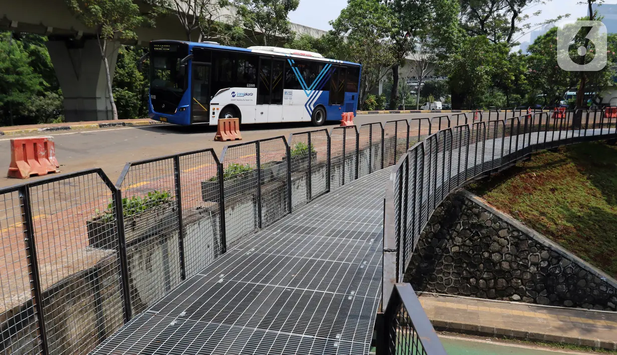 Bus Transjakarta melintas dekat fasilitas pejalan kaki di Taman Semanggi, Jakarta, Rabu (12/10/2022). Gubernur DKI Jakarta Anies Baswedan menyatakan pembangunan fasilitas pejalan kaki dan jalur sepeda itu bertujuan untuk memberikan ruang interaksi dan oase baru bagi warga Ibu Kota dan sekitarnya. (Liputan6.com/Herman Zakharia)