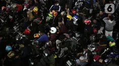 Ratusan pemudik bersepeda motor antre menunggu giliran masuk ke kapal "Roll on-Roll off" (RoRo) di Pelabuhan Merak, Banten, Kamis (28/4/2022). Puncak arus mudik H-3 lebaran di Pelabuhan Merak sudah dipenuhi oleh pemudik. Tampak, pemudik yang membawa anak kecil serta barang bawaan yang diikat di belakang motor. (Liputan6.com/Angga Yuniar)