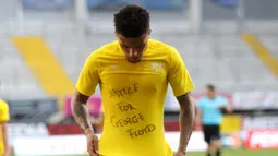 Gelandang Borrusia Dortmund, Jadon Sancho berselebrasi menunjukkan tulisan di kaos dalam 'Justice for George Floyd' usai mencetak gol ke gawang SC Paderborn 07 di Benteler Arena di Paderborn, Jerman (1/6/2020). Dalam pertandingan ini Dortmund menang telak 6-1 atas Paderborn. (Lars Baron/Pool via AP)