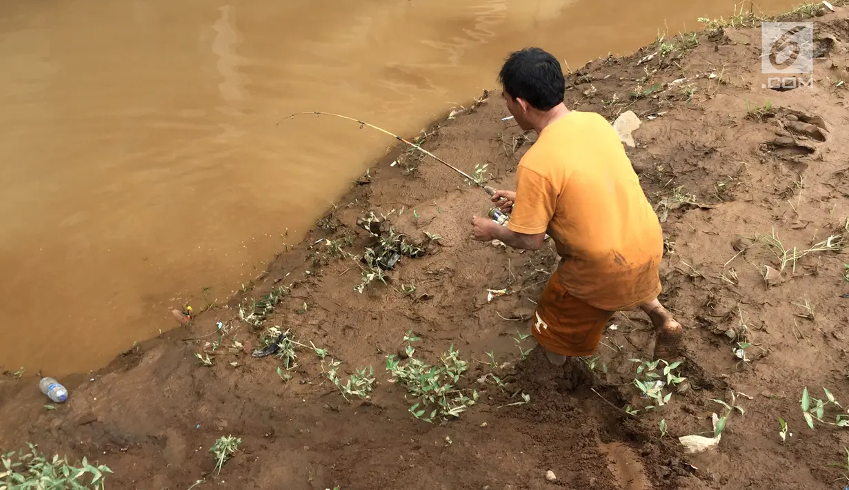 Seorang warga melemparkan mata kail saat memancing di Sungai Ciliwung, Rawajati,Jakarta, Selasa (6/2). (Liputan6.com/Immanuel Antonius)