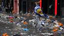 Seorang penggemar Skotlandia berjalan di antara sampah yang ditinggalkan oleh penggemar yang berpesta sebelum pertandingan grup D kejuaraan sepak bola Euro 2020 antara Inggris dan Skotlandia, di London, Jumat (18/6/2021).  (AP Photo/Kirsty Wigglesworth)