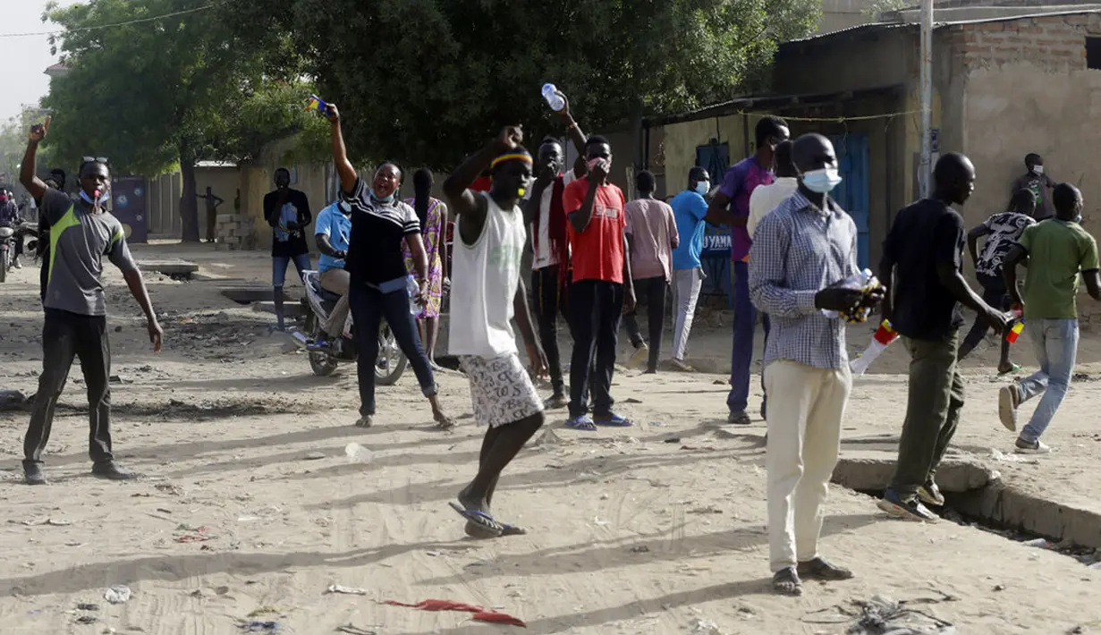 Orang-orang melakukan protes di jalanan di N'Djamena, Chad, Selasa (27/4/2021). Ribuan orang melakukan protes dan dua orang tewas dalam demonstrasi menentang aturan dewan militer transisi yang dipimpin putra Presiden Idriss Deby Itno yang terbunuh minggu lalu. (AP Photo/Sunday Alamba)