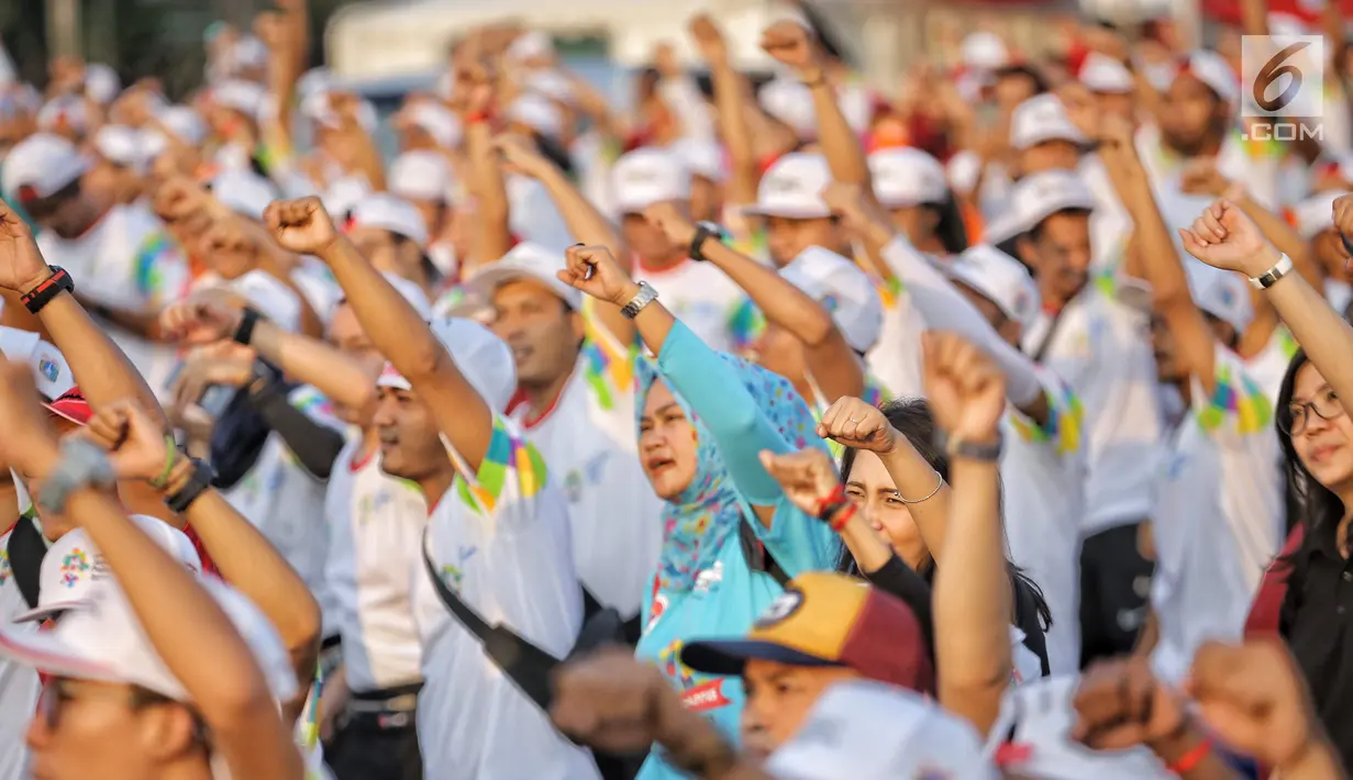 Warga mengikuti gerakan senam sembari menunggu prosesi Torch Relay Asian Games 2018 di Jakarta, Sabtu (18/8). Hari ini merupakan puncak kirab obor Asian Games 2018 dimana api abadi akan berlabuh di Gelora Bung Karno. (Liputan6.com/Faizal Fanani)