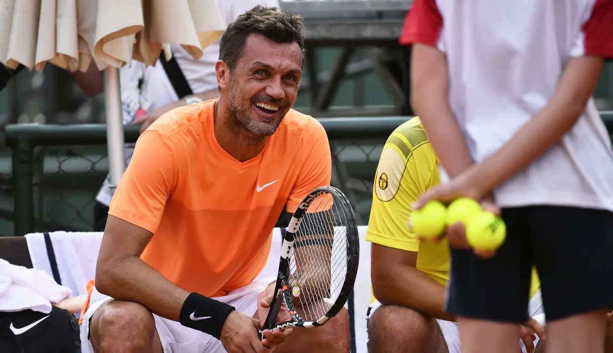 Paolo Maldini tertawa saat mengikuti tenis ATP Challenger Tour. Maldini berpasangan  Stefano Landonio melawan Tomasz Bednarek dan David Pel di Aspria Tennis Club, Milan, (27/6/2017). Maldini kalah 1-6, 1-6. (AFP/ Marco Bertorello)