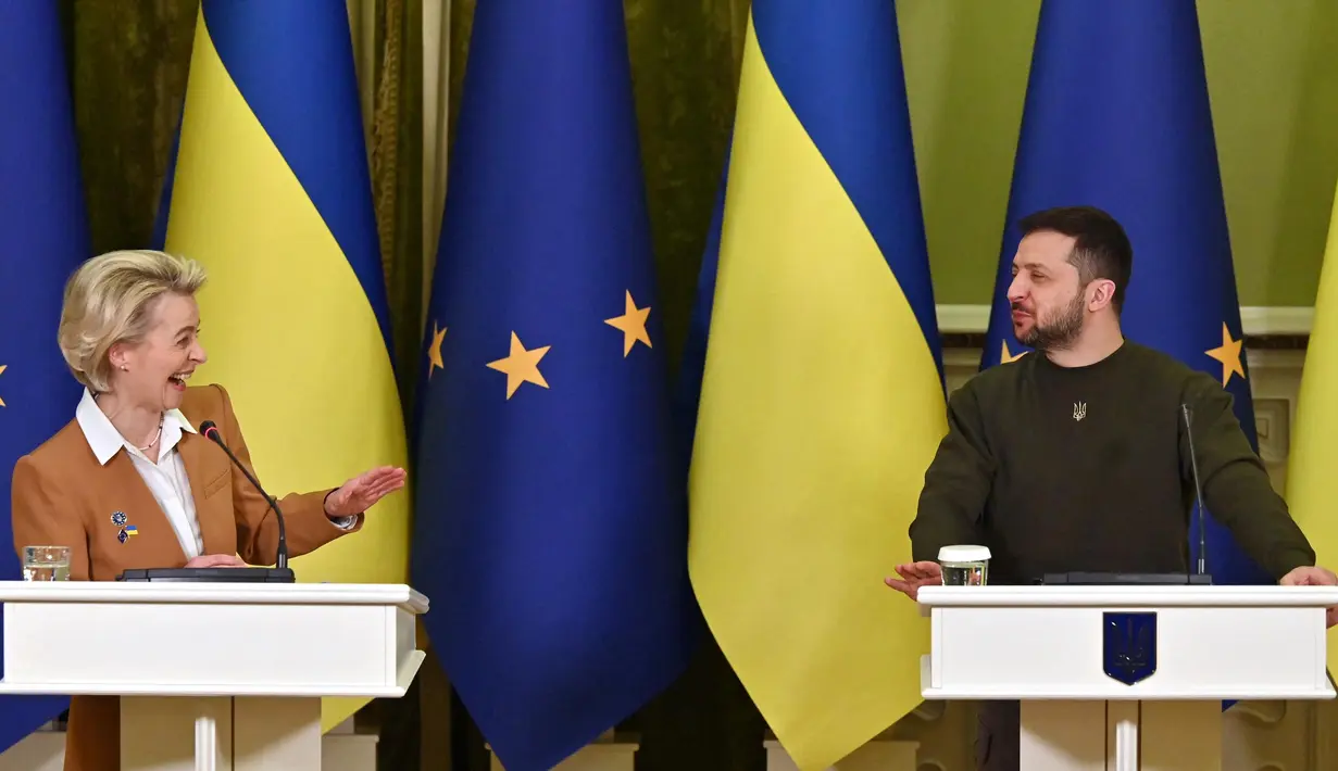 Presiden Ukraina Volodymyr Zelensky (kanan) dan Presiden Komisi Eropa Ursula von der Leyen tertawa dalam sebuah konferensi pers bersama setelah pembicaraan di Kyiv, Kamis (2/2/2023). Uni Eropa berencana untuk memberi Rusia dengan sanksi baru pada hari peringatan invasi Moskow ke Ukraina, kata kepala Komisi Eropa. (Sergei SUPINSKY/AFP)