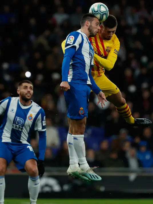 Bek Barcelona, Clement Lenglet melompat saat berebut bola dengan pemain Espanyol Jonathan Calleri pada pekan ke-19 La Liga di RCDE Stadium, Sabtu (4/1/2020). Hampir saja menang, Barcelona harus puas menerima hasil imbang 2-2 atas Espanyol. (AP/Joan Monfort)