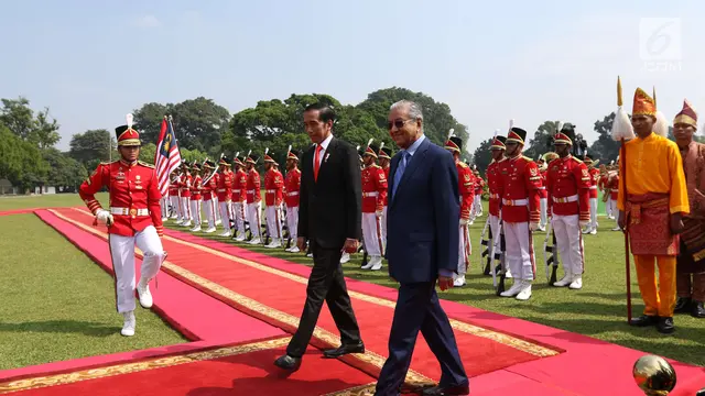 Presiden Joko Widodo bersama PM Malaysia, Mahathir Mohamad memeriksa pasukan saat kunjungan kenegaraan di Istana Bogor, Jumat (29/6). Indonesia menjadi negara pertama yang dikunjungi secara resmi oleh PM Mahathir usai dilantik. (Liputan6.com/Angga Yuniar)